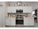 Kitchen features white cabinets, stainless steel appliances, and neutral countertops at 318 Stone Castle Loop, Lady Lake, FL 32159