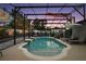 A screened pool with a slide and patio furniture sits in a lush backyard at 318 Stone Castle Loop, Lady Lake, FL 32159