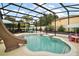 A screened-in pool area with a slide, perfect for relaxing and entertaining at 318 Stone Castle Loop, Lady Lake, FL 32159