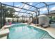 Inviting pool with slide and shaded lounge chairs surrounded by a screen enclosure at 318 Stone Castle Loop, Lady Lake, FL 32159