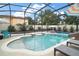 An inviting pool with slide, surrounded by a screened lanai, is great for entertaining at 318 Stone Castle Loop, Lady Lake, FL 32159
