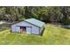 Aerial view of the barn featuring sliding doors, a green roof, and a white fence at 32025 Timberlake Dr, Mount Dora, FL 32757