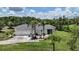 Home with an attached three-car garage, screened-in patio, and palm trees, providing a comfortable outdoor space at 32025 Timberlake Dr, Mount Dora, FL 32757
