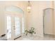 Bright foyer featuring tile floors, a statement light fixture, and double glass doors at 32025 Timberlake Dr, Mount Dora, FL 32757