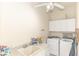 Bright laundry room with modern white appliances, neutral paint, and tile flooring at 32025 Timberlake Dr, Mount Dora, FL 32757