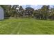 Green lawn provides a view of the house and surrounding trees, adding to the property's appeal at 32025 Timberlake Dr, Mount Dora, FL 32757