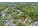 Wide aerial shot of the home situated in a lush, leafy suburban setting with mature trees at 3904 Valencia Grove Ln, Orlando, FL 32817