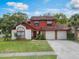 Charming two-story home with a well-maintained lawn and an attached two-car garage at 3904 Valencia Grove Ln, Orlando, FL 32817