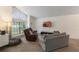 Bright living room featuring neutral carpet, a large window, and comfortable seating arrangement at 3904 Valencia Grove Ln, Orlando, FL 32817