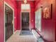 The home has a red foyer with a dark wooden front door, painted walls, and tiled flooring at 428 Coventry Estates Blvd, Deltona, FL 32725