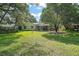 The backyard features lush green grass and a screened-in lanai, perfect for outdoor entertaining at 4300 Leafway Cir, Leesburg, FL 34748