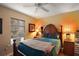 Warm bedroom with wooden furnishings, a ceiling fan, and natural light from a window at 4300 Leafway Cir, Leesburg, FL 34748