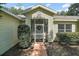 Charming front entrance featuring a screened enclosure and mature landscaping at 4300 Leafway Cir, Leesburg, FL 34748
