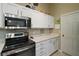 Kitchen with stainless steel microwave and range, white cabinets, and granite countertops at 4300 Leafway Cir, Leesburg, FL 34748
