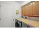 Functional laundry room with modern washer and dryer, storage cabinets, and a doorway at 4300 Leafway Cir, Leesburg, FL 34748