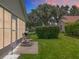 Serene backyard scene with a patio, rocking chair, grill, and a hedge under a dusk sky at 4520 Eaglewood Dr, Leesburg, FL 34748