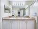 Bathroom featuring a double sink vanity with white cabinets and a large mirror at 4520 Eaglewood Dr, Leesburg, FL 34748