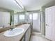 Bright bathroom featuring a double sink vanity, large mirror, and glass-enclosed shower with two doors at 4520 Eaglewood Dr, Leesburg, FL 34748