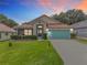 Charming single-story home featuring a well-manicured lawn and a bright blue garage door at 4520 Eaglewood Dr, Leesburg, FL 34748