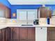 This is a well-designed kitchen with sleek countertops, dark wood cabinets, and stainless steel appliances for a modern look at 4520 Eaglewood Dr, Leesburg, FL 34748