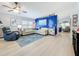 Bright living room with modern furniture, a ceiling fan, and a striking blue accent wall at 4520 Eaglewood Dr, Leesburg, FL 34748