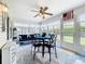 Bright sunroom with a ceiling fan, large windows, a table with four chairs, and a comfortable blue sofa at 4520 Eaglewood Dr, Leesburg, FL 34748