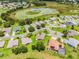 An aerial view shows the home's location in a neighborhood near a lush green field and pond at 5620 Illumination Ln, Leesburg, FL 34748