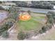 An aerial view of a baseball field, featuring well-maintained grass and surrounding trees at 5620 Illumination Ln, Leesburg, FL 34748