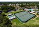 Aerial view of the community tennis courts with pickle ball and shuffleboard courts on a sunny day at 5620 Illumination Ln, Leesburg, FL 34748