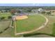 Aerial view of the community baseball field with players, trees, and parking lot nearby at 5620 Illumination Ln, Leesburg, FL 34748