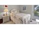 Cozy bedroom featuring a comfortable bed with a decorative quilt and a quaint bedside table with a lamp at 5620 Illumination Ln, Leesburg, FL 34748