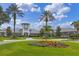 Stunning community clubhouse featuring lush landscaping, vibrant flower beds, and a welcoming entrance for residents and guests at 5620 Illumination Ln, Leesburg, FL 34748