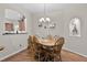 Dining room features hardwood floors, a chandelier, and easy access to kitchen at 5620 Illumination Ln, Leesburg, FL 34748