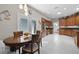Eat-in kitchen features stainless steel appliances, wood cabinets, white tile flooring, and access to laundry room at 5620 Illumination Ln, Leesburg, FL 34748