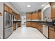 Bright eat-in kitchen features stainless steel appliances, wood cabinets, and a pass-through to adjacent rooms at 5620 Illumination Ln, Leesburg, FL 34748