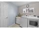 Practical laundry room with washer, dryer, utility sink, window, and neutral tones at 5620 Illumination Ln, Leesburg, FL 34748