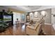 Cozy living room features hardwood floors, neutral paint, tray ceiling with fan, and sliding door access to porch at 5620 Illumination Ln, Leesburg, FL 34748