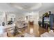 Spacious open-concept living room boasts hardwood floors, a tray ceiling, and flows into the dining and kitchen areas at 5620 Illumination Ln, Leesburg, FL 34748
