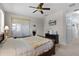 Spacious bedroom with neutral tones, featuring a large bed, dresser, and access to a closet at 5620 Illumination Ln, Leesburg, FL 34748
