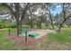 Outdoor shuffleboard courts with benches, nestled among mature trees, offering a recreational area at 5620 Illumination Ln, Leesburg, FL 34748