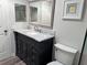 Updated bathroom with black vanity, marble countertop, modern fixtures, and decorative mirror at 627 Nuevo Leon Ln, The Villages, FL 32159