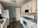 Well-maintained kitchen featuring white cabinetry, stone countertops, and modern appliances at 627 Nuevo Leon Ln, The Villages, FL 32159
