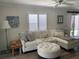 Comfortable living room with ample seating, natural light, and views of the backyard at 627 Nuevo Leon Ln, The Villages, FL 32159