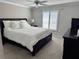 Bright main bedroom with ceiling fan, large windows, and a luxurious dark wood sleigh bed at 627 Nuevo Leon Ln, The Villages, FL 32159