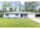 Charming single-story home features a well-maintained lawn, blue shutters, and a matching door at 8161 Cr 647, Bushnell, FL 33513