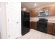 Updated kitchen with black appliances, wood cabinetry, and easy access to doorways at 8161 Cr 647, Bushnell, FL 33513