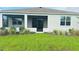 View of the house's backyard, featuring a screened-in porch and manicured landscaping at 8949 Sw 76Th St, Ocala, FL 34481