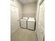 Bright laundry room featuring a washer, dryer, wire shelving and tile flooring at 8949 Sw 76Th St, Ocala, FL 34481