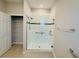 Modern bathroom featuring a glass shower with a showerhead, grab bar, and a tiled accent stripe at 8949 Sw 76Th St, Ocala, FL 34481