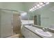Bathroom with double sinks, a large mirror, and a walk-in shower at 911 Beverly Harbors Dr # 16, Leesburg, FL 34748